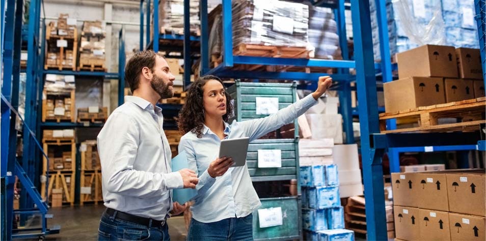 Man and woman evaluate warehouse inventory